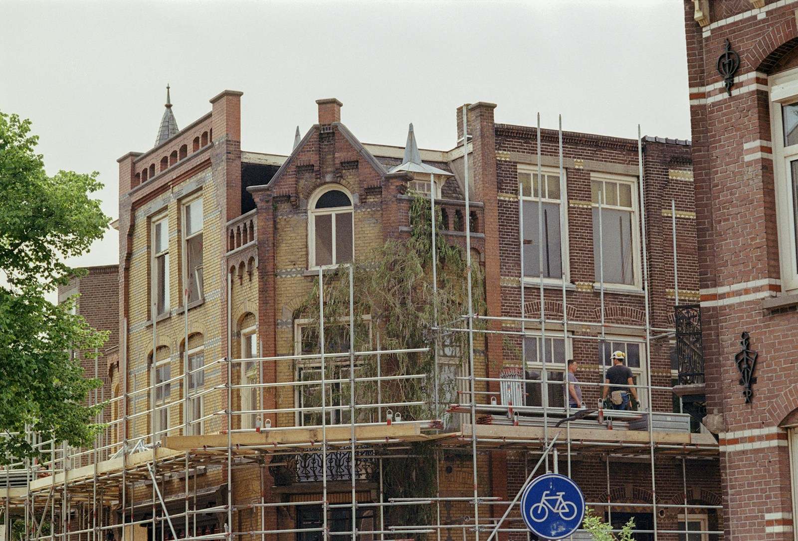 Bakstenen hoekgebouw met een stelling tegen de gevel